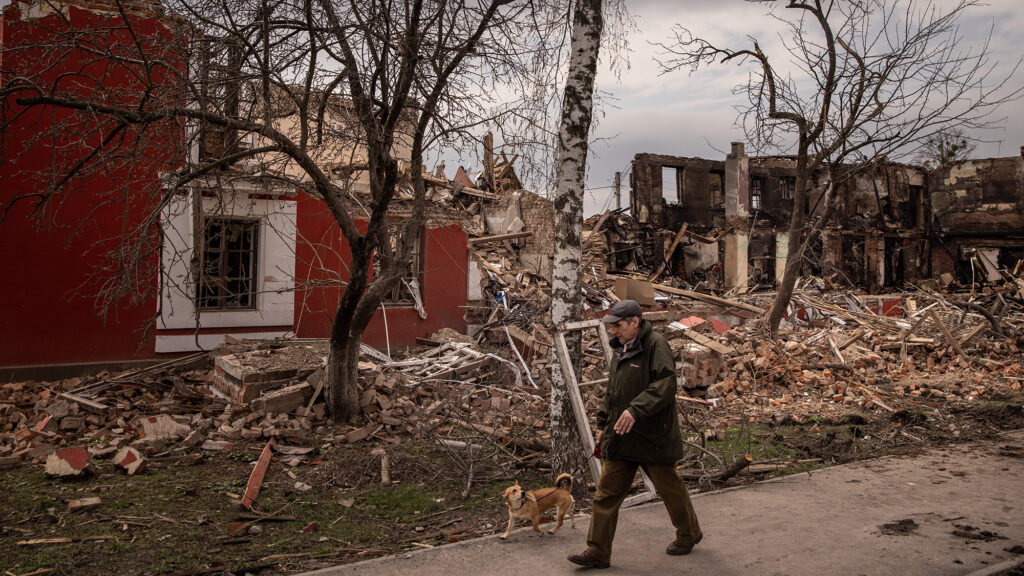 A man walks his dog past a building destroyed by recent Russian shelling in Kharkiv, Ukraine on April 14.