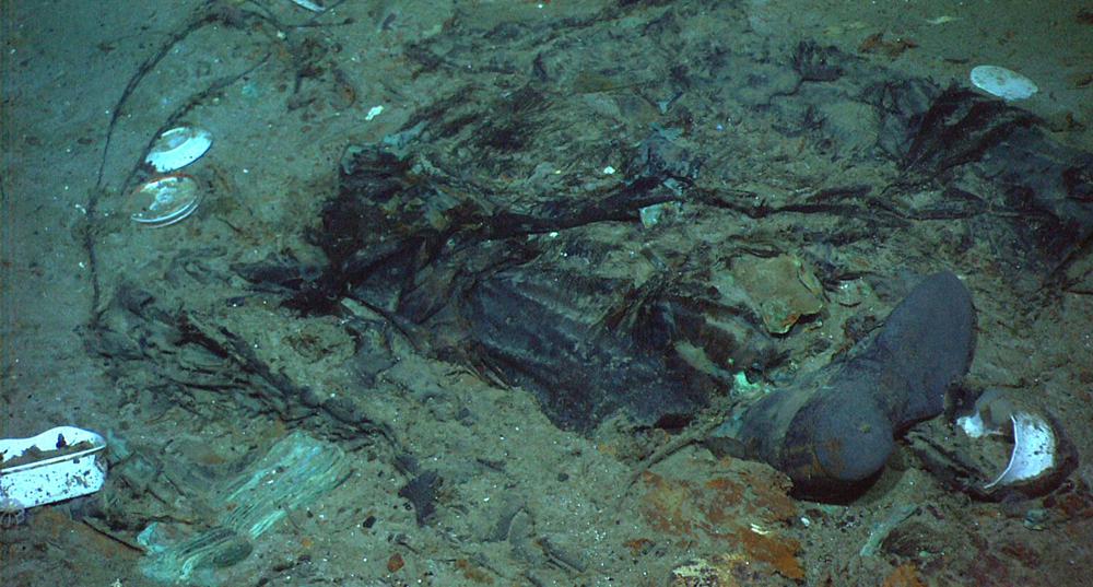 FILE - This 2004 photo provided by the Institute for Exploration, Center for Archaeological Oceanography/University of Rhode Island/NOAA Office of Ocean Exploration, shows the remains of a coat and boots in the mud on the sea bed near the Titanic's stern. The Associated Press on Friday, June 23, 2023 reported on social media posts falsely claiming that photographs showed the remains of OceanGate's Titan submersible after U.S. authorities reported the deaths of all five people on board. (Institute for Exploration, Center for Archaeological Oceanography/University of Rhode Island/NOAA Office of Ocean Exploration, File)